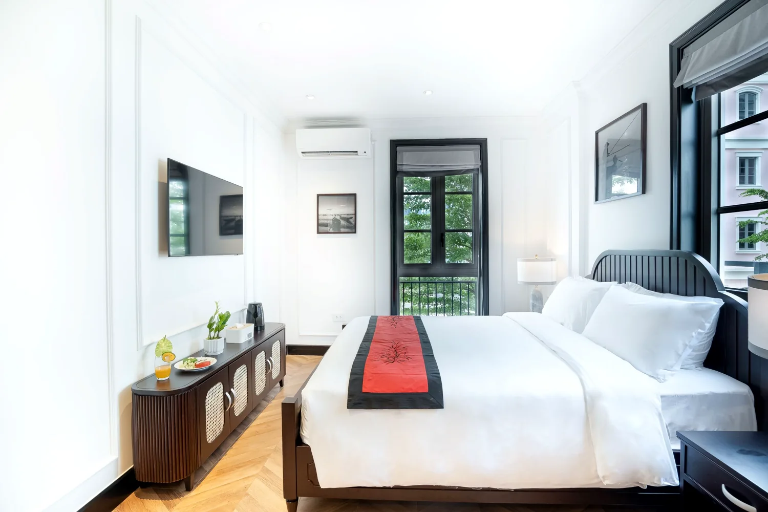 Bright La Rose Classic room with white linens, a red-and-black runner and French windows